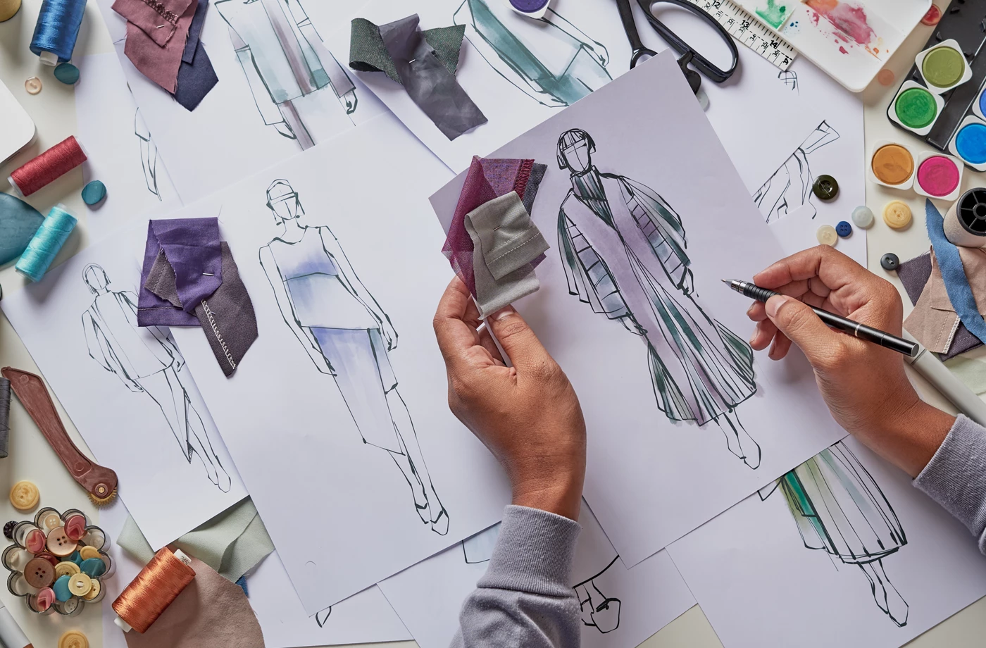Le styliste de mode dessine des croquis stylisés de tissu en tissu Costume. Studio d'atelier créatif.
